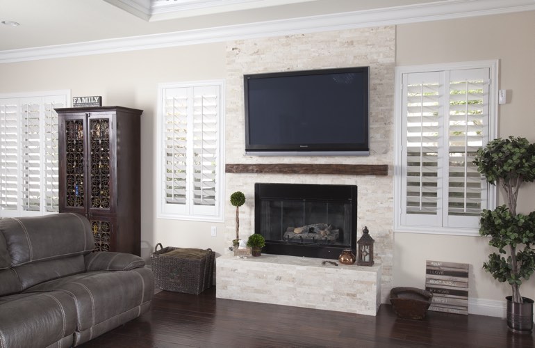 White plantation shutters in a Indianapolis living room with dark hardwood floors.